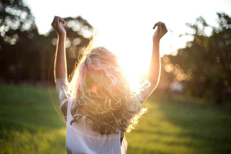 Inspirational Quotes for Her: inspired woman on her back looking at the sunset