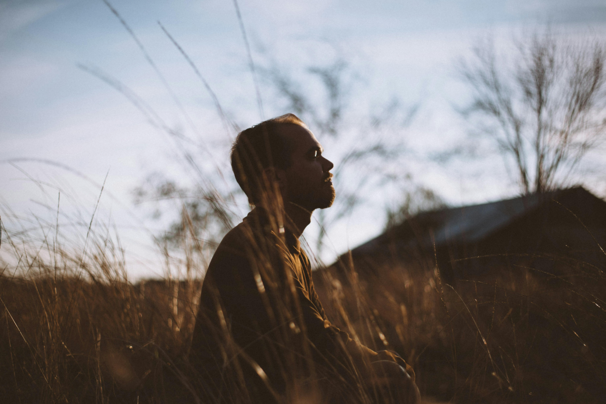 overthinking: a man meditating on the field