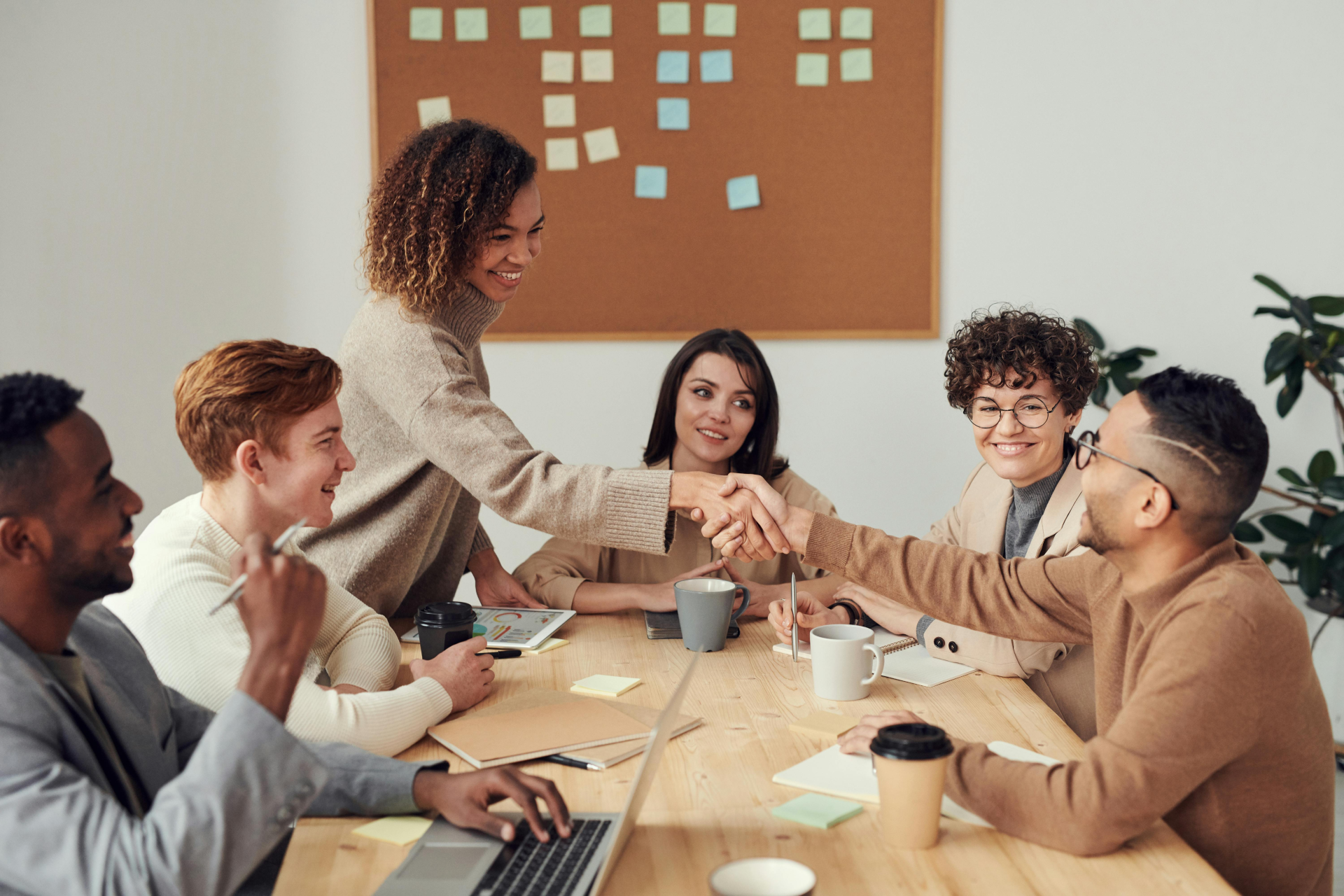 Providing Support To Team Members : a team having a meeting and congratulating one person showing support