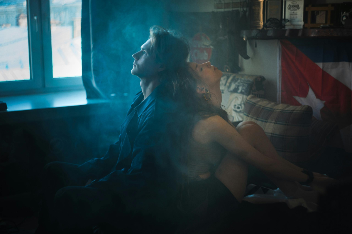 overthinking: couple sitting back to back on the bed