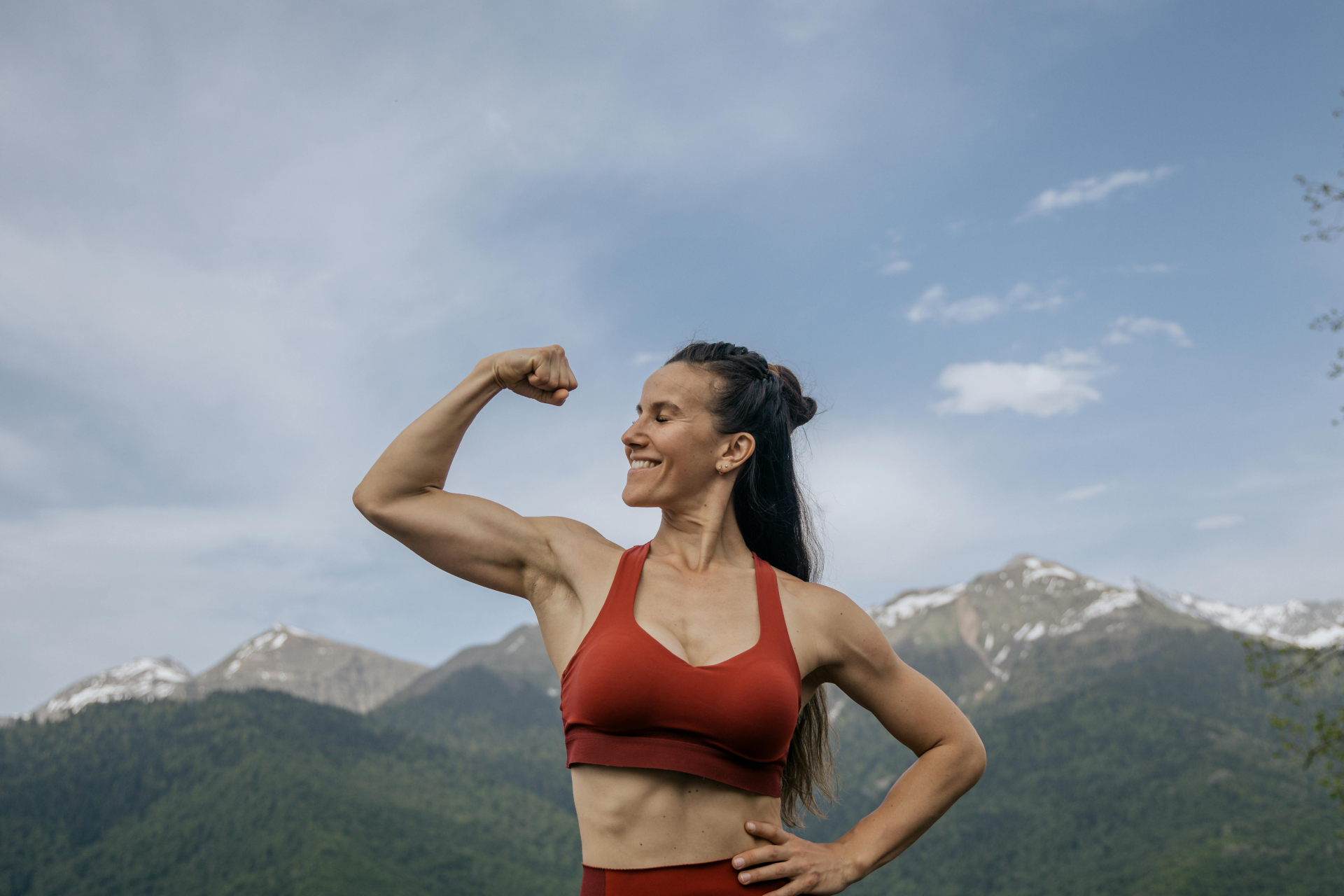 Strength and Happiness: mascular woman flexing her muscles smiling