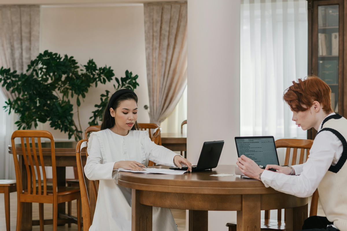 work smarter not harder: two students studying on their laptop in a cozy place